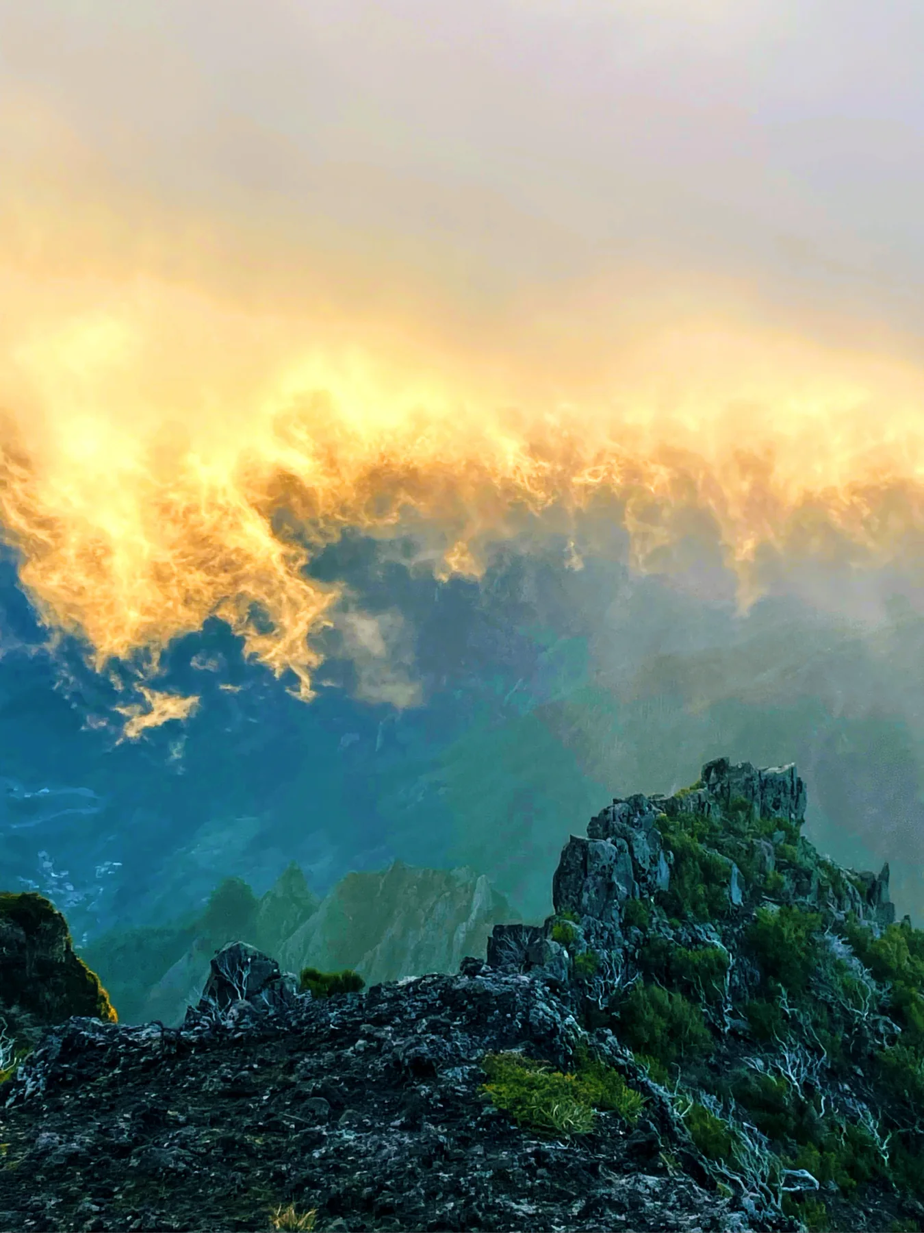 Dark mountain ridge under glowing cloud and firelike evening light