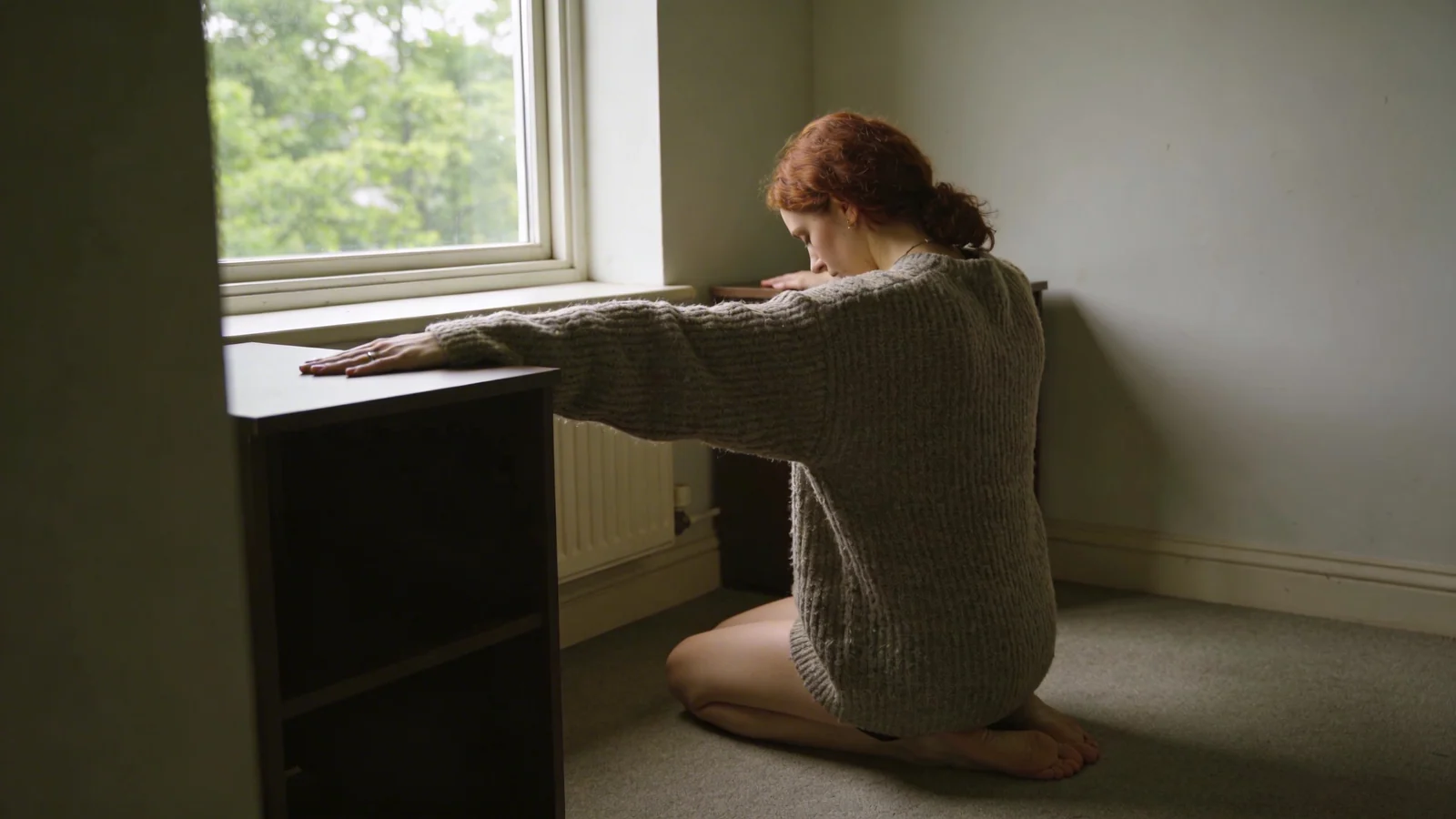 Man practicing somatic practices for nervous system regulation with palms pressed flat on desk in natural light
