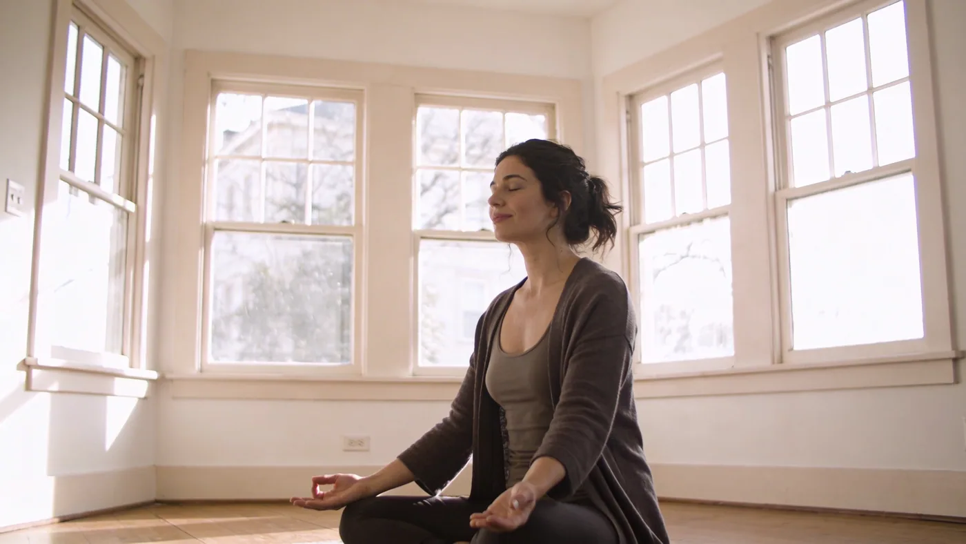 Man sitting on floor with palms down and eyes closed showing nervous system relief after long-term b Man sitting on floor with palms down and eyes closed showing nervous system relief after long-term bypassing — spiritual bypassing nervous system
