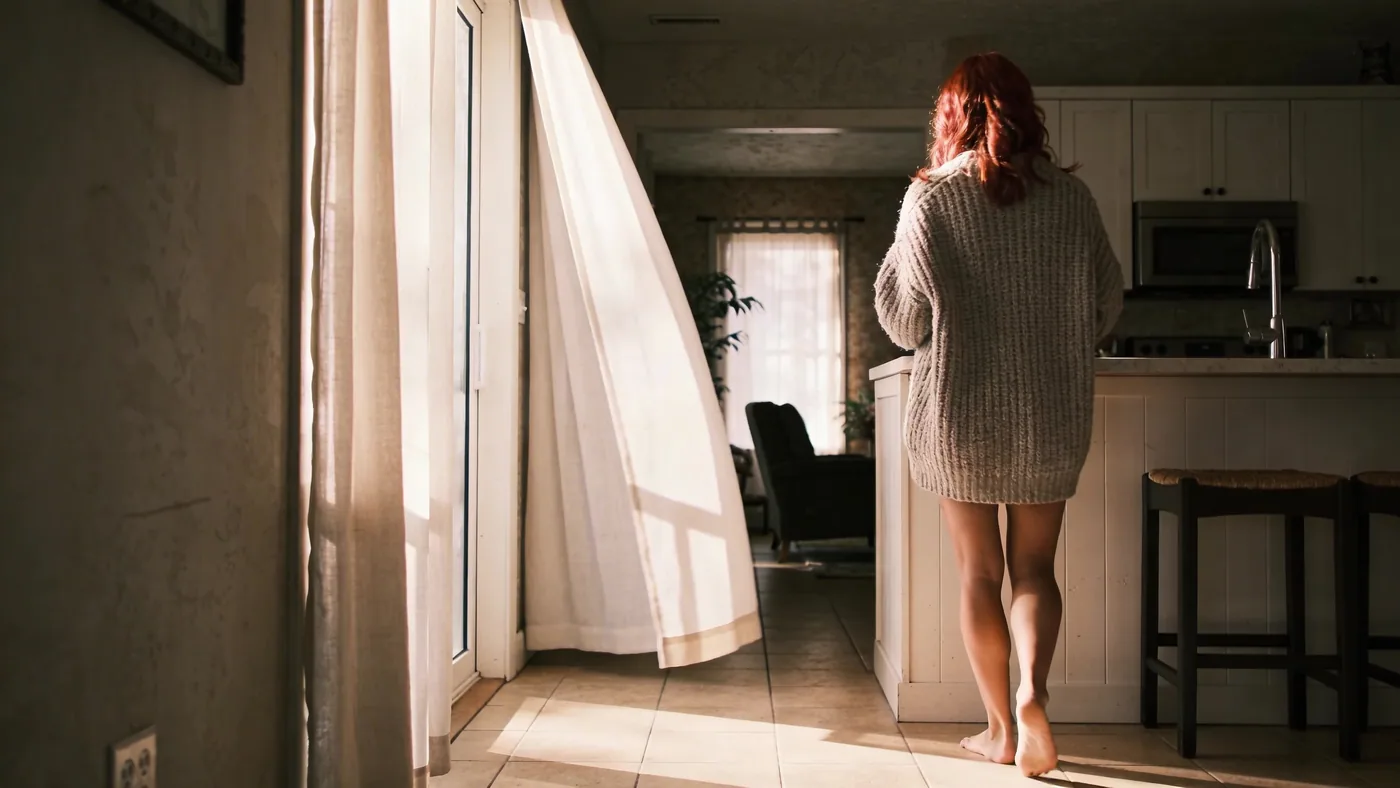 Man standing alone at kitchen counter with heavy shoulders showing self-betrayal repeated until it f Man standing alone at kitchen counter with heavy shoulders showing self-betrayal repeated until it feels like identity — why do i hate myself real reason