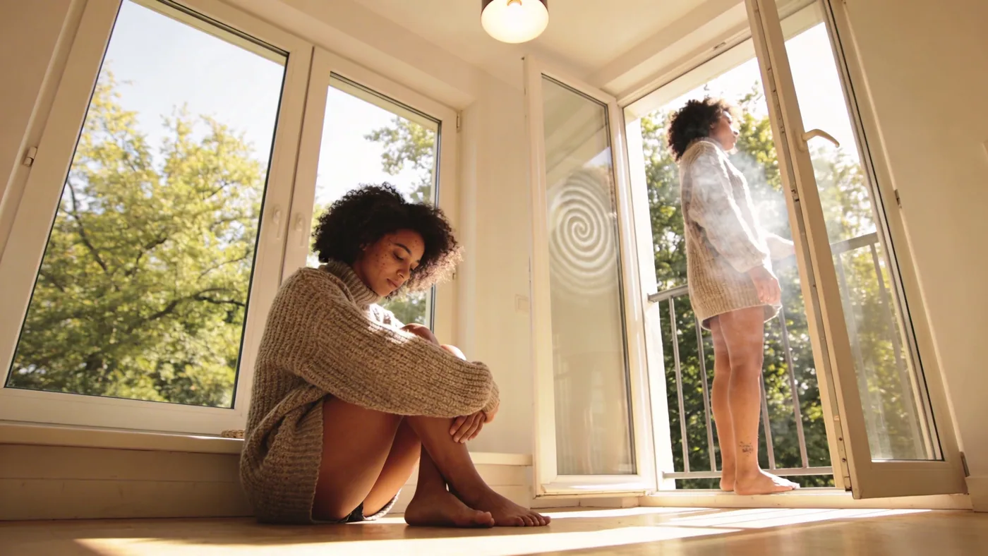Man standing at open balcony door in side profile with visible breath showing the pattern behind the overthinking spiral — why do i overthink everything