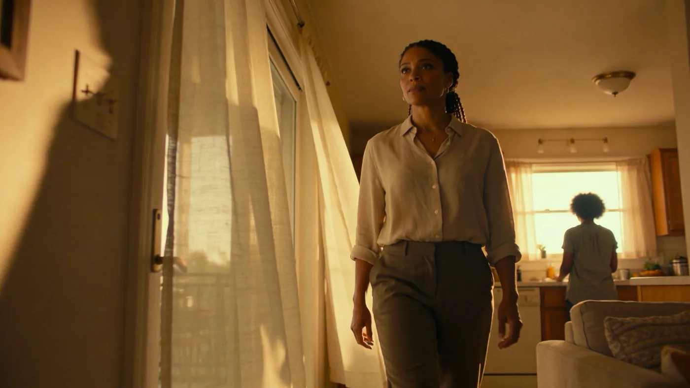 Person standing at kitchen window in morning light, inner child healing contemplative moment