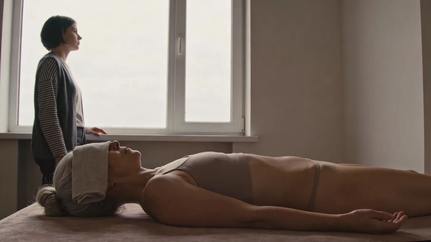 Person standing at window in contemplative moment, learning how to practice self-love through accept Person standing at window in contemplative moment, learning how to practice self-love through acceptance