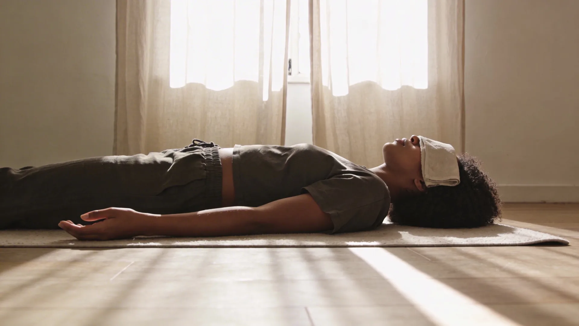 Woman opening a curtain in a dim hallway as light streams in during a self love practice that shifts something