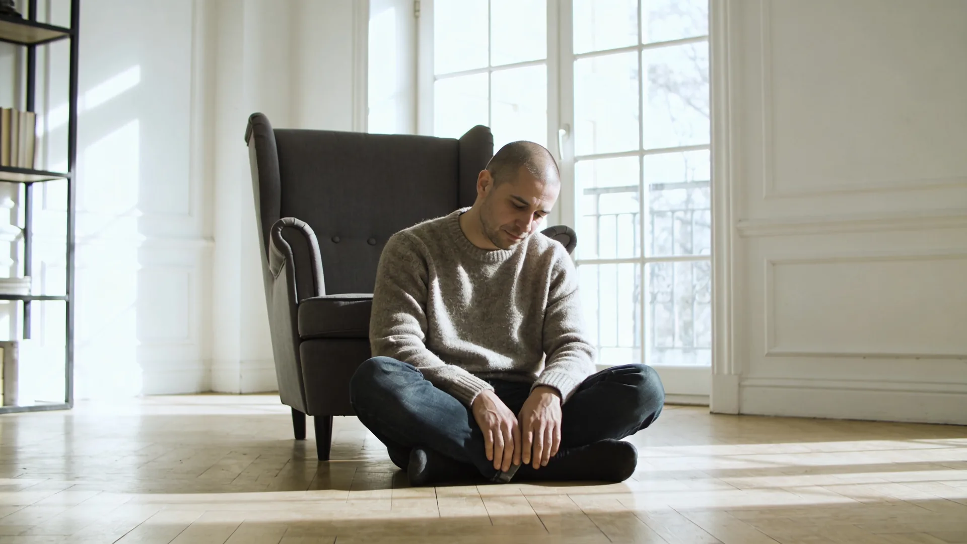 Person lying on wooden floor in Feeling Session posture with eyes covered exploring why anticipatory grief hurts