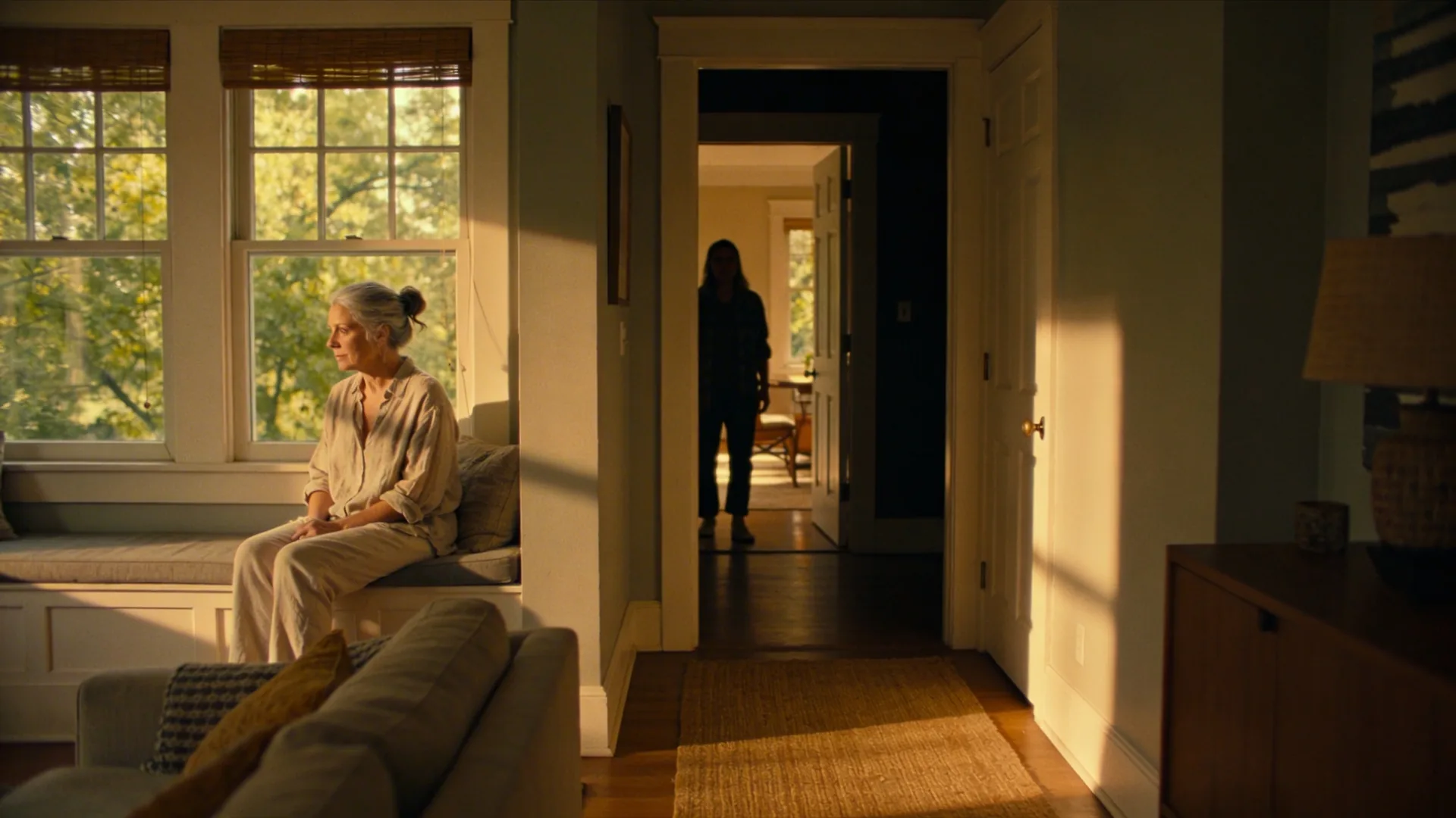 Person pausing at hallway threshold between dark and light rooms recognizing the pattern most people miss