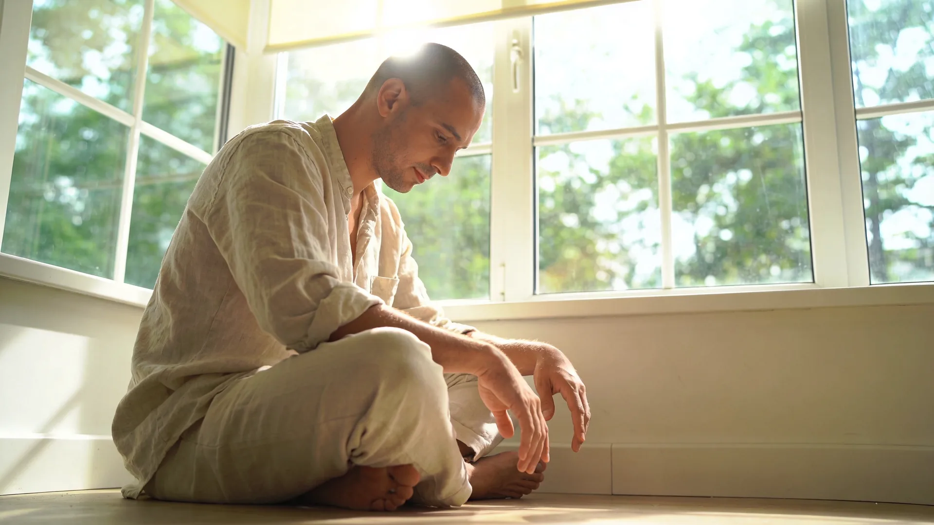 Woman lying in Feeling Session posture on wooden floor with palms down showing what changes when you stop fighting emotional exhaustion signals