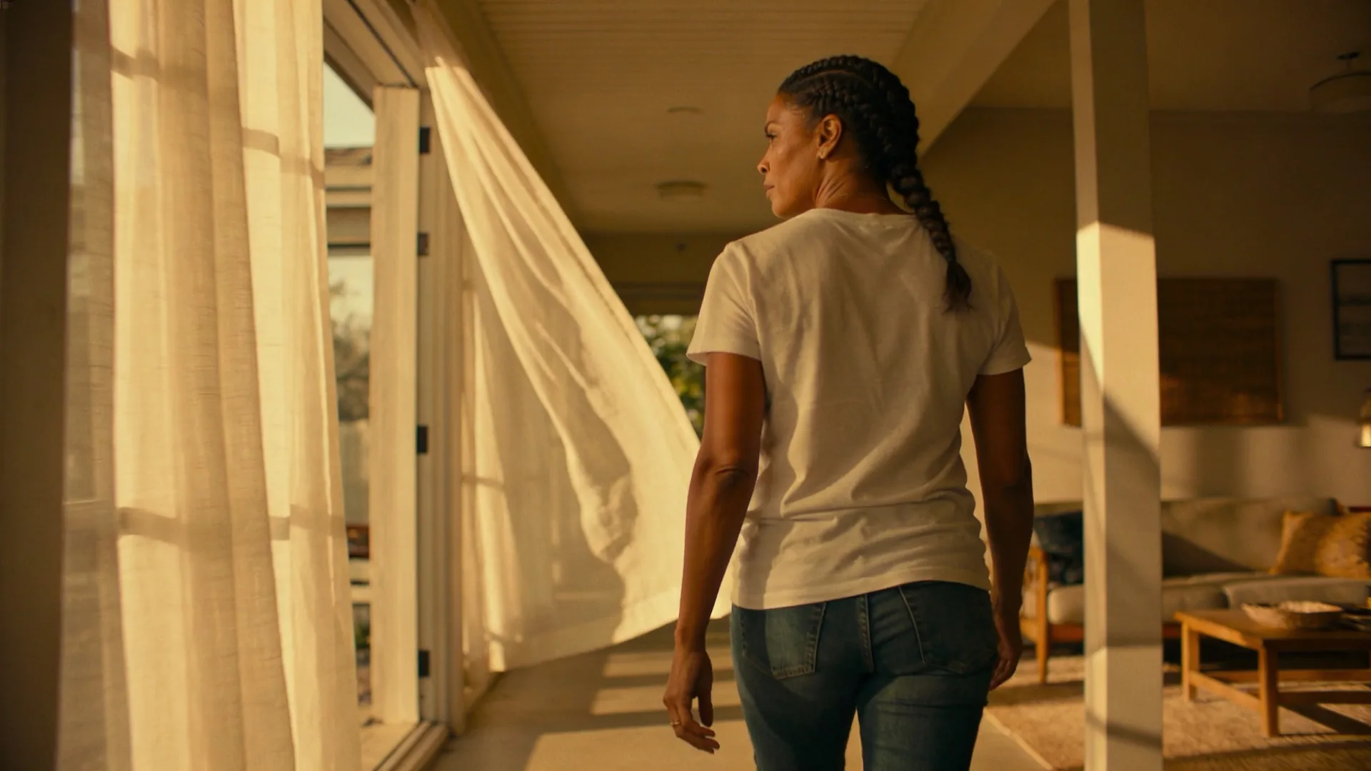 Woman standing at open balcony door breathing in daylight, showing why emotional validation hits the body first