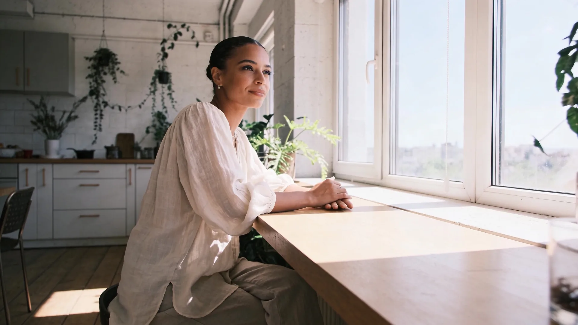 Man sitting on a wooden floor in natural window light with relaxed body posture showing what changed and softened through shadow work