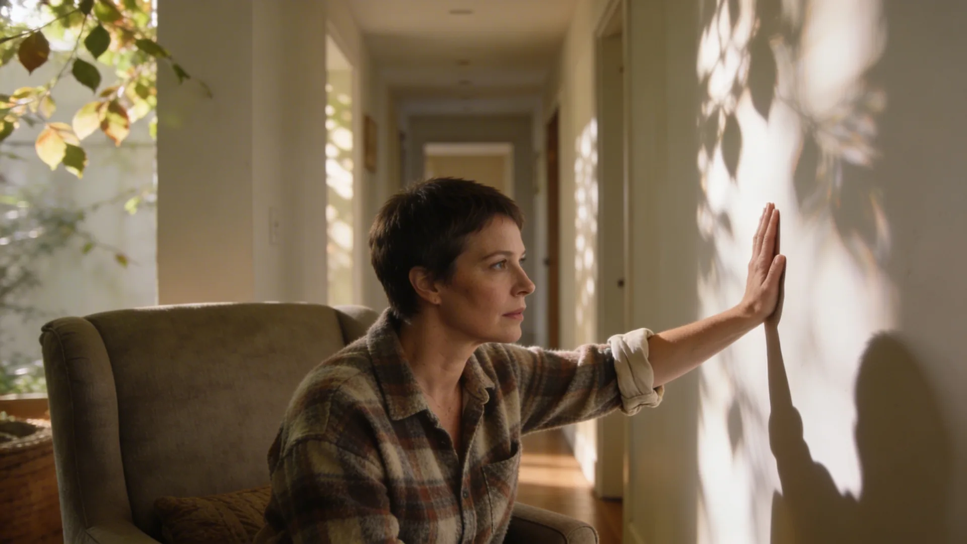 Woman pausing mid-step in hallway with hand on wall practicing grounded interruption of push-pull pattern