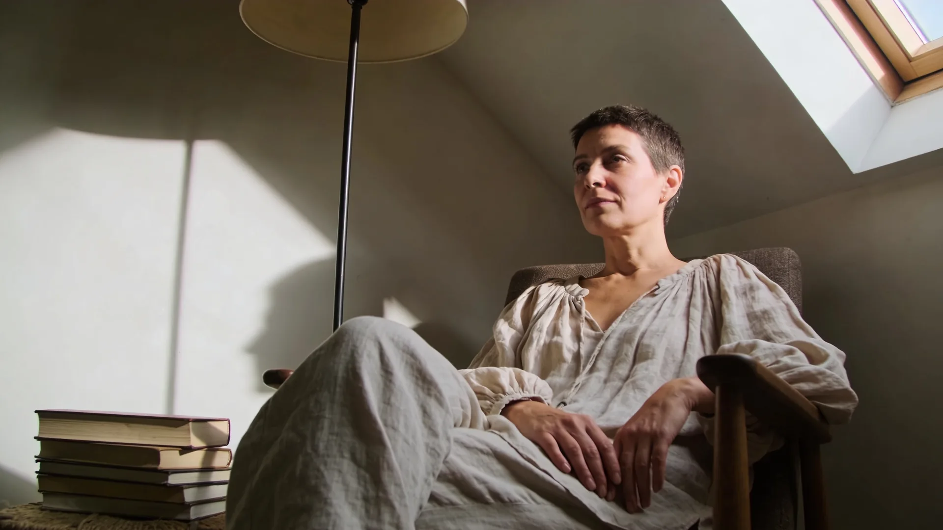 Person curled in a window seat [feeling like a burden](/self-worth/feeling-like-a-burden/) to others, forehead against glass in a quiet living room