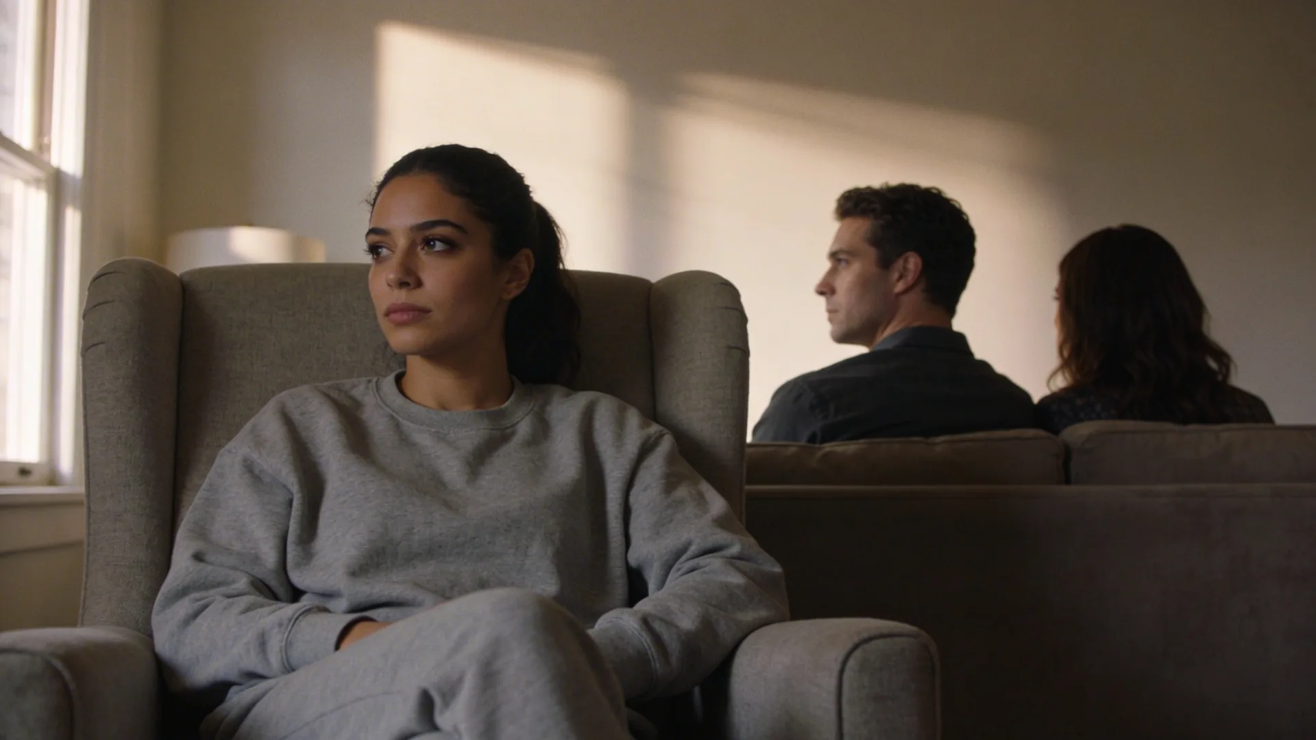 Couple sitting apart on sofa looking away from each other, feeling lonely in relationship despite physical closeness