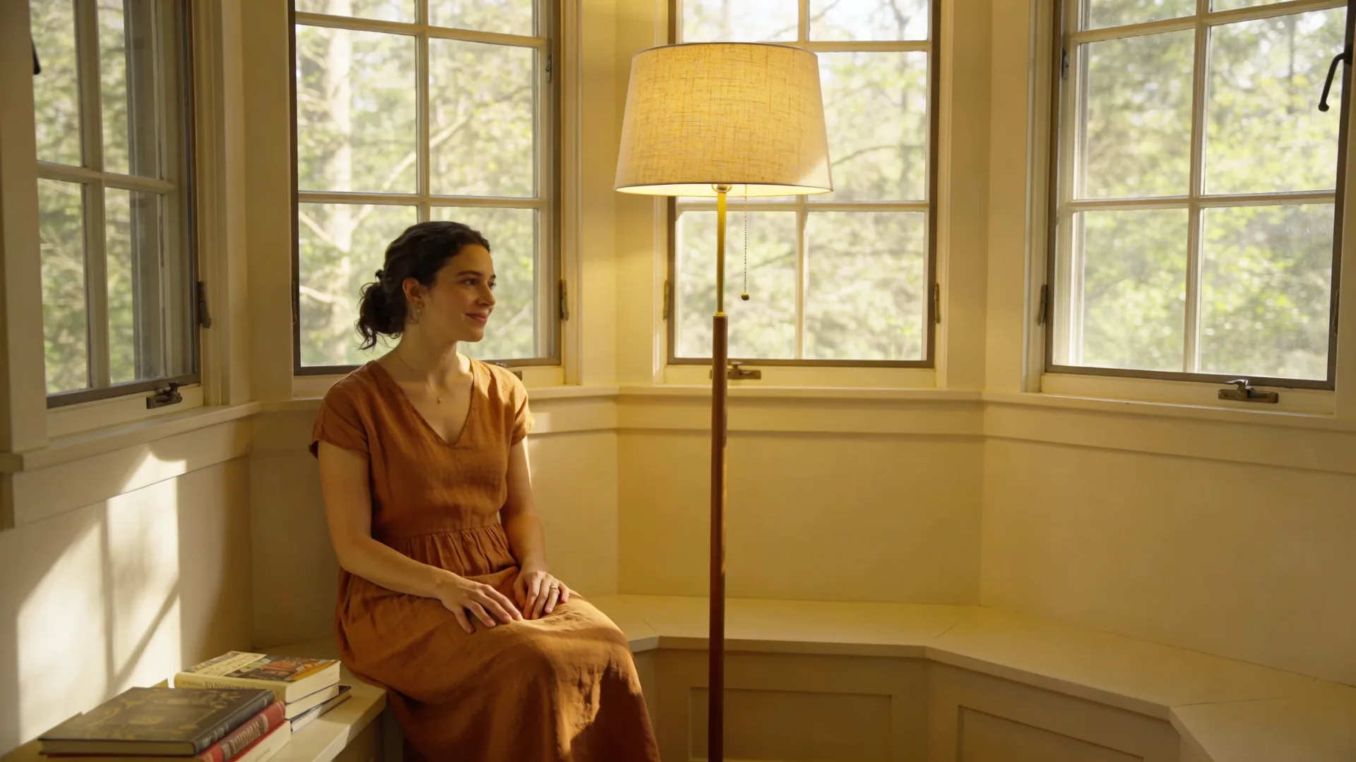 Woman standing at a balcony doorway in soft light, body relaxed as the trauma loop begins to loosen
