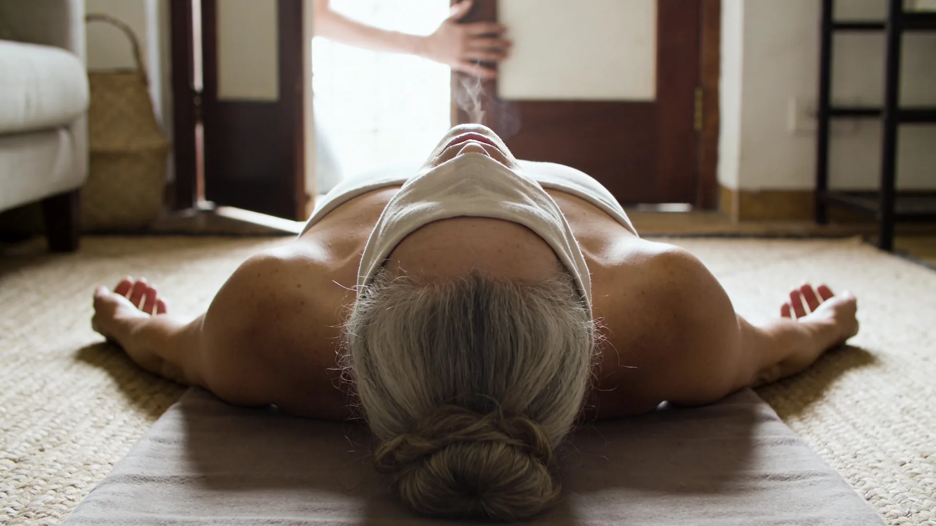 Woman exhaling near an open doorway with hand on chest showing what changes after you stop performing calm