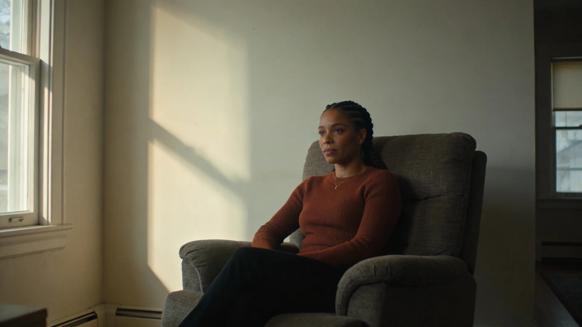 Woman learning how to be real with people pausing alone in sunlit kitchen with shoulders dropping in quiet release