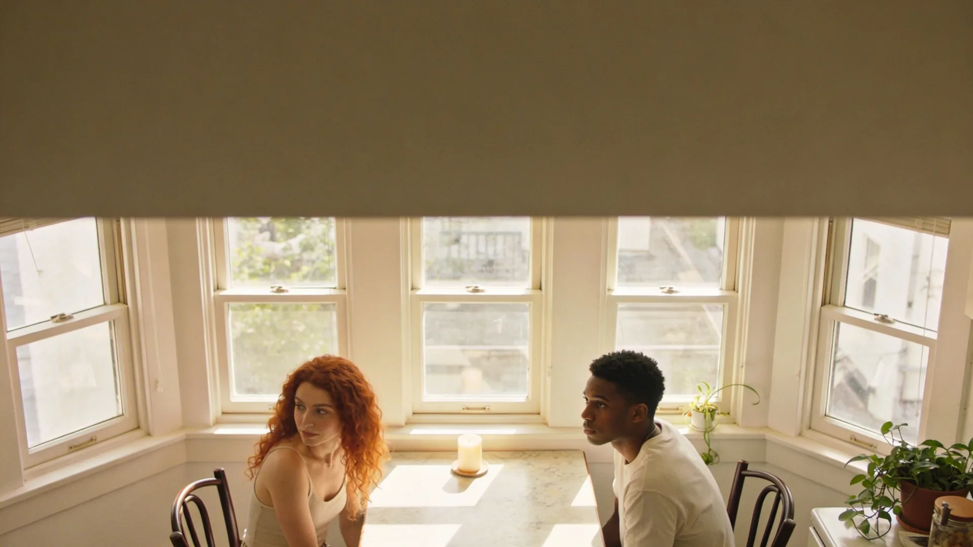 Two chairs and candle at small table representing the conversation format that builds trust and emotional intimacy