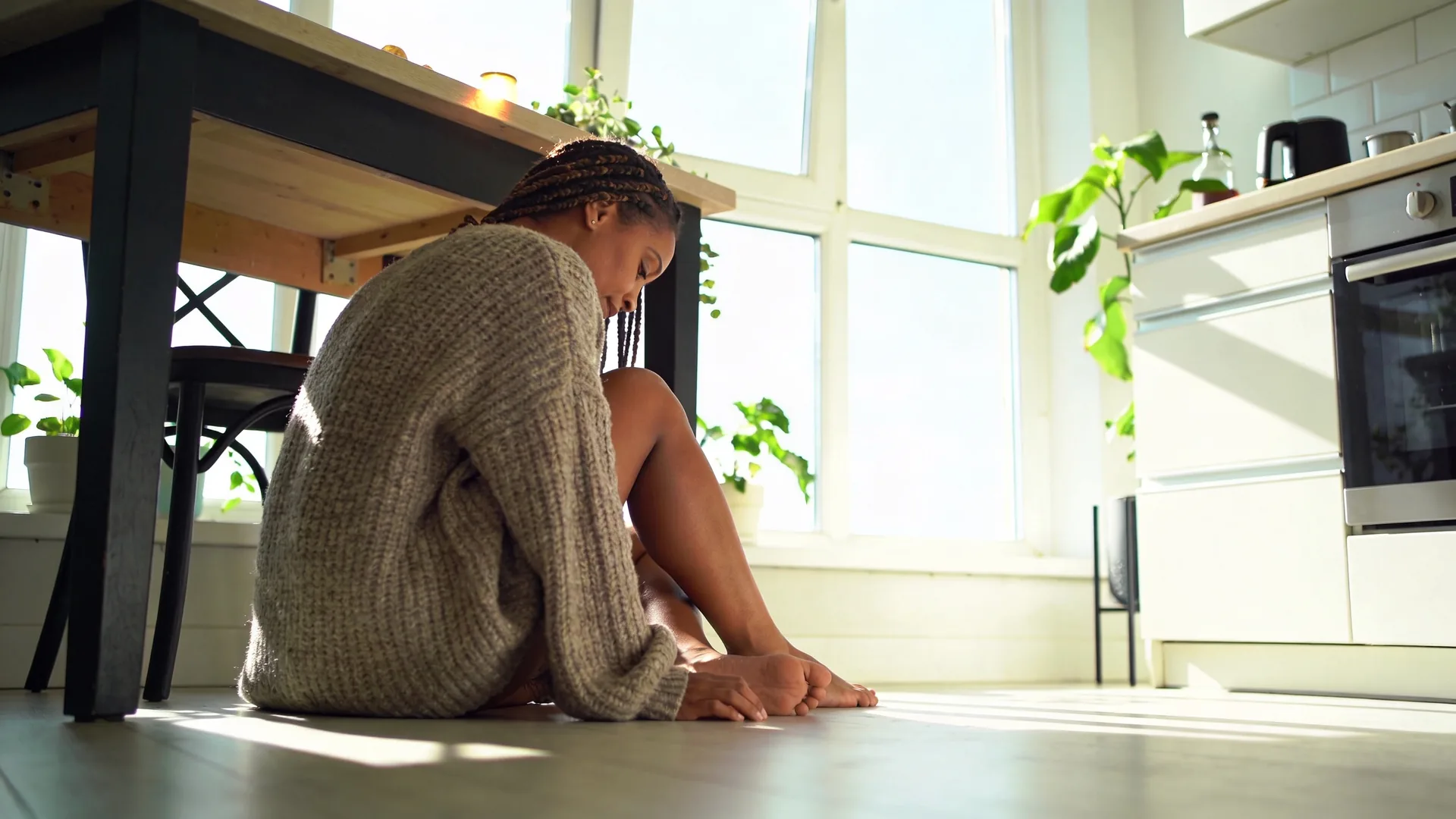 Woman standing at open balcony door in morning light showing what changes after one honest emotional safety practice