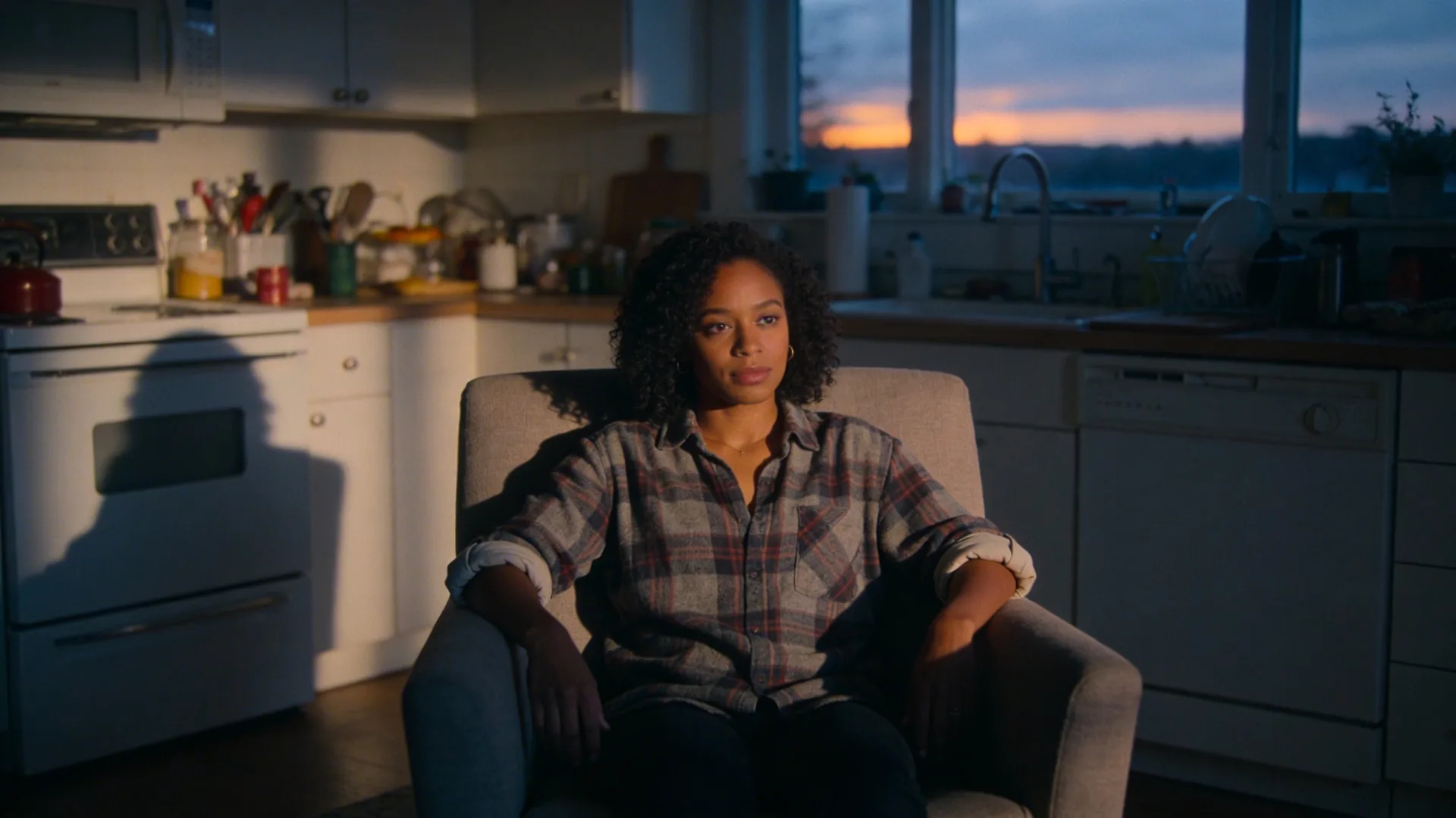Woman pausing alone in sunlit kitchen learning how to do shadow work through body awareness