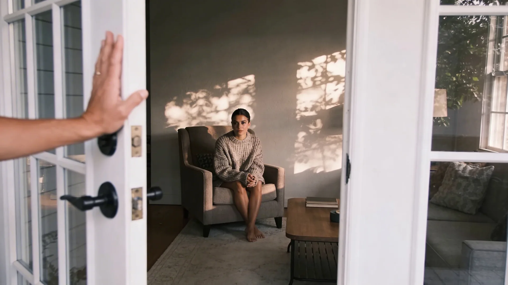 Woman pausing at doorway with hand on frame showing what changes after one honest repetition of connection