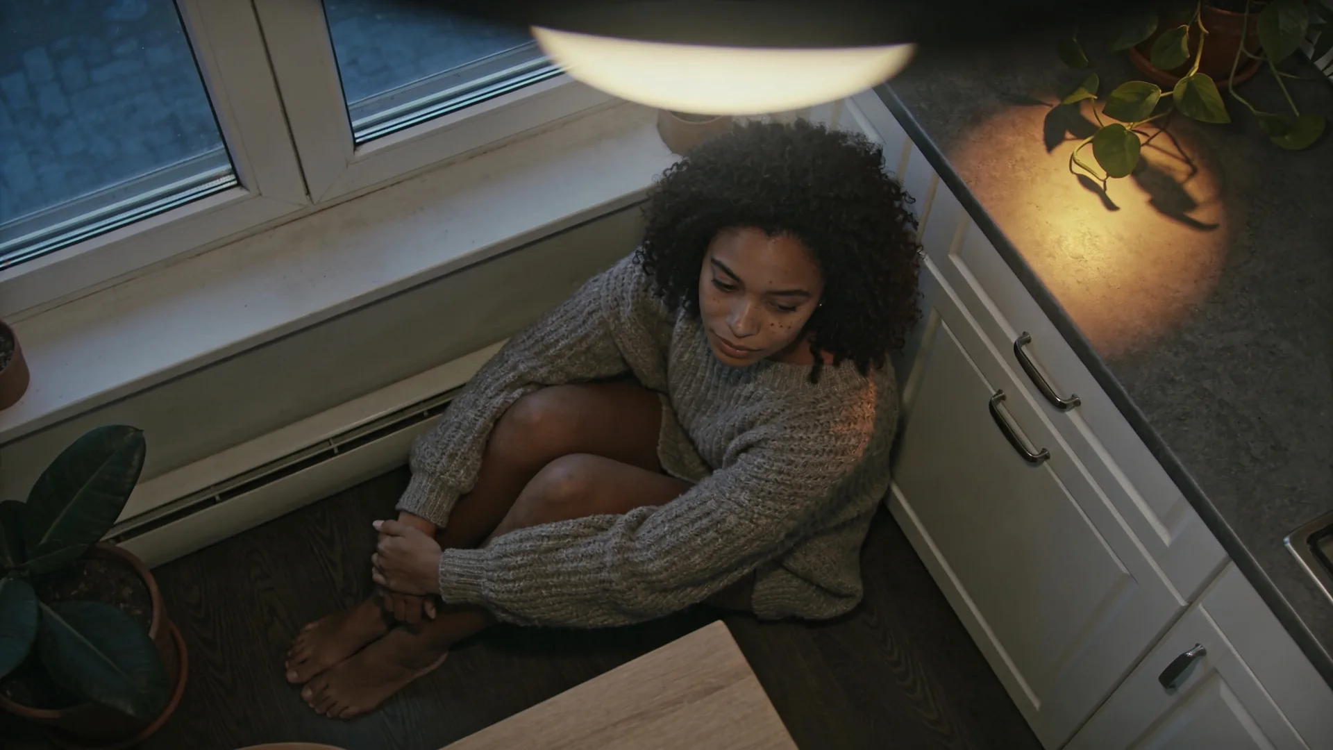 Overhead view of person standing before floor mirror learning how to love yourself in warm bedroom light