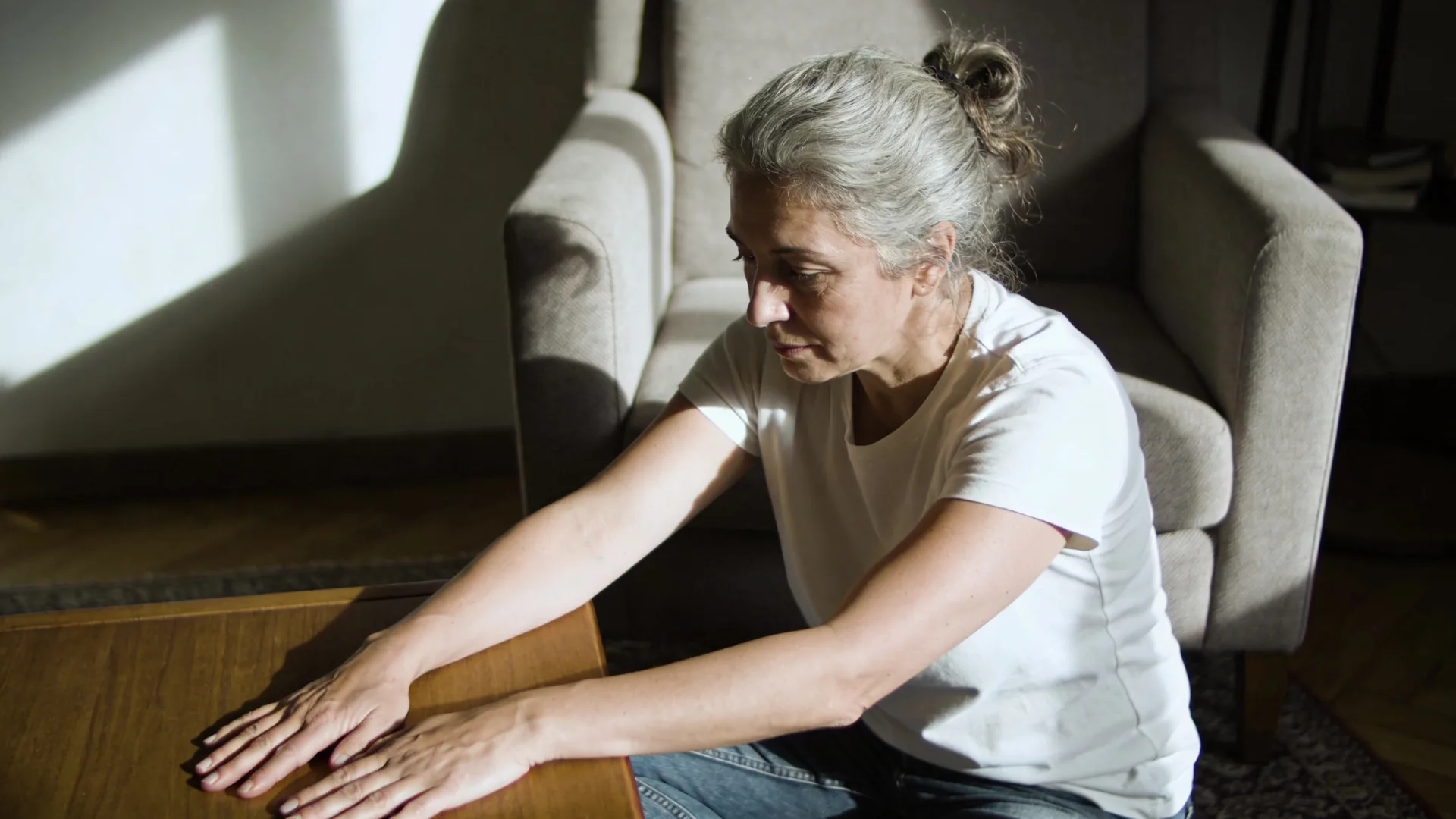 Relaxed hands resting palms down on wooden table during grounded practice when insecurity spikes