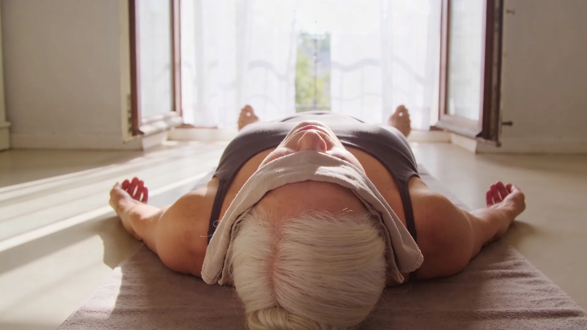 Woman with throat exposed to morning light near open window showing what changes when self-compassion starts working
