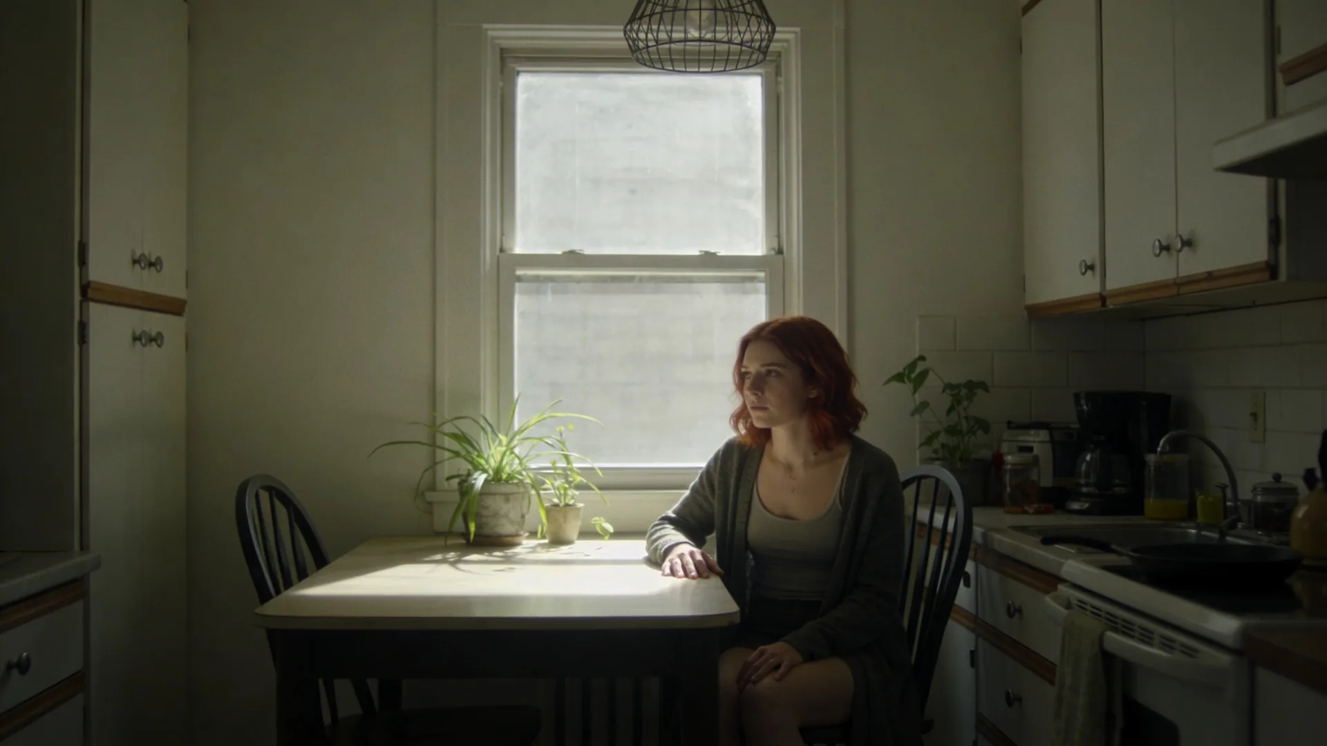 Man standing at rain-streaked window in a quiet room, reflecting the disorientation of losing a parent