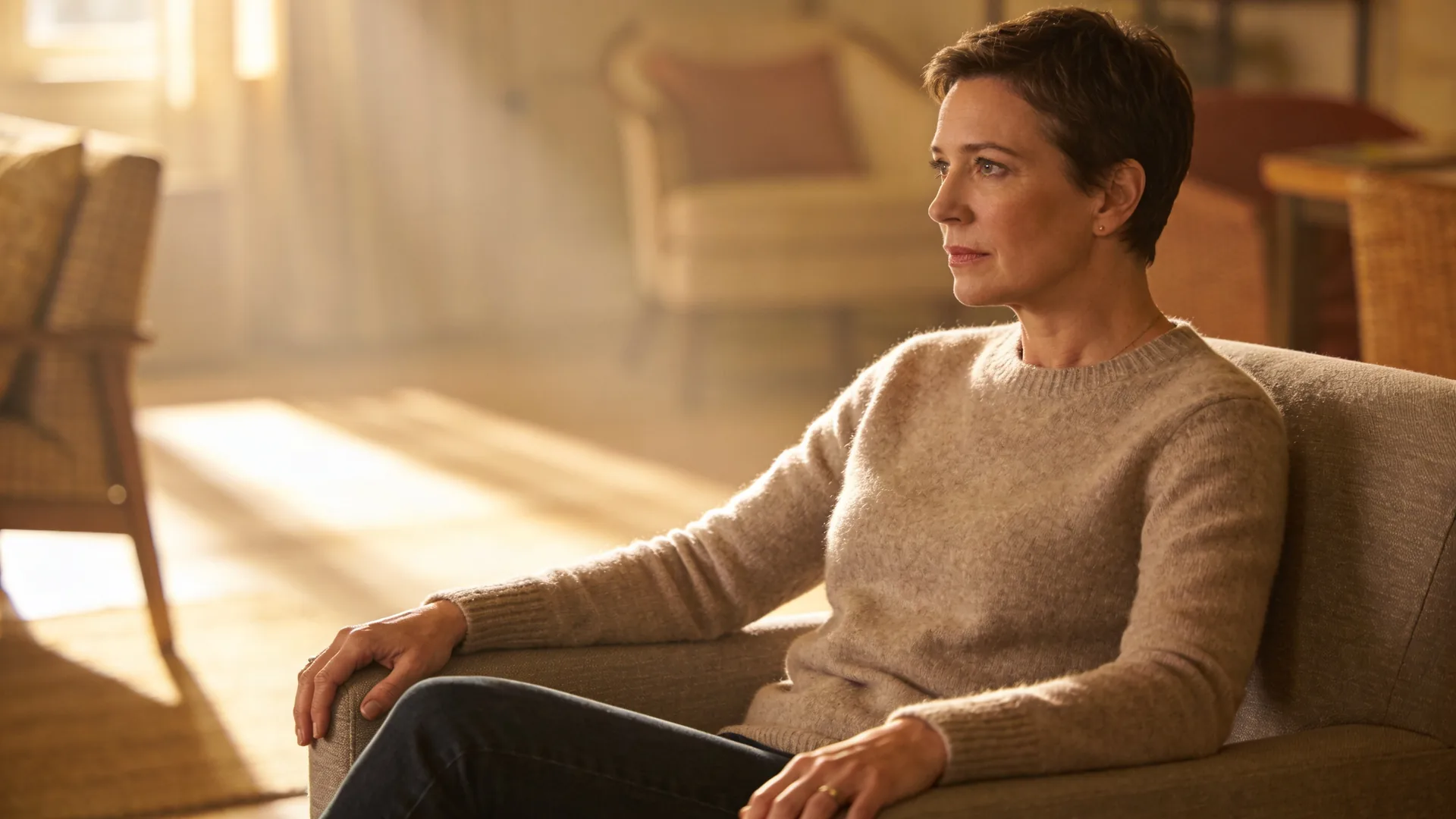 Two people sitting quietly together on a couch with soft daylight between them, next step in mourning
