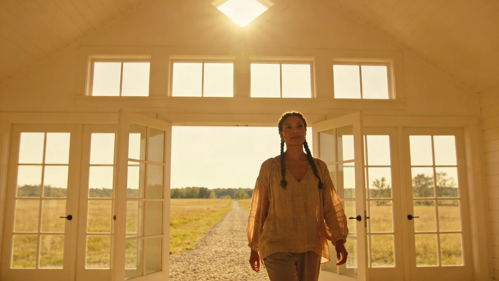 Woman walking a gravel path through an open field embodying non-dual awareness as movement