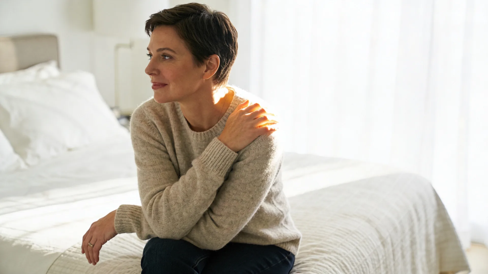 Two women sitting quietly together on a couch in soft daylight during a self compassion meditation moment