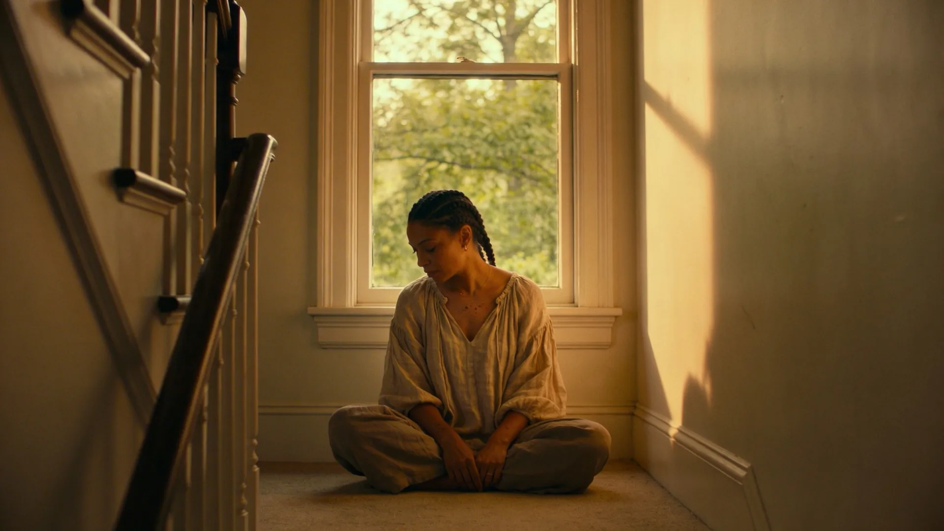 Woman pausing mid-step on interior staircase in natural light, what changes when you practice shadow work this way