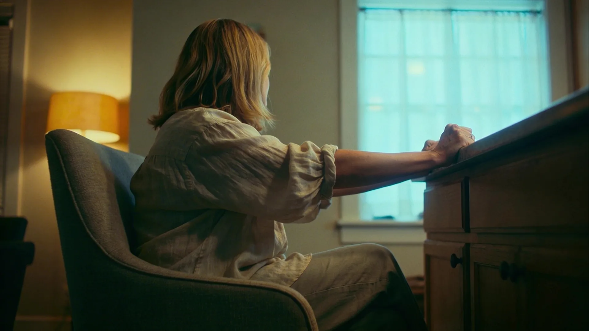 Close-up of tense hands gripping a kitchen table edge, revealing signs of spiritual bypassing hidden in everyday life