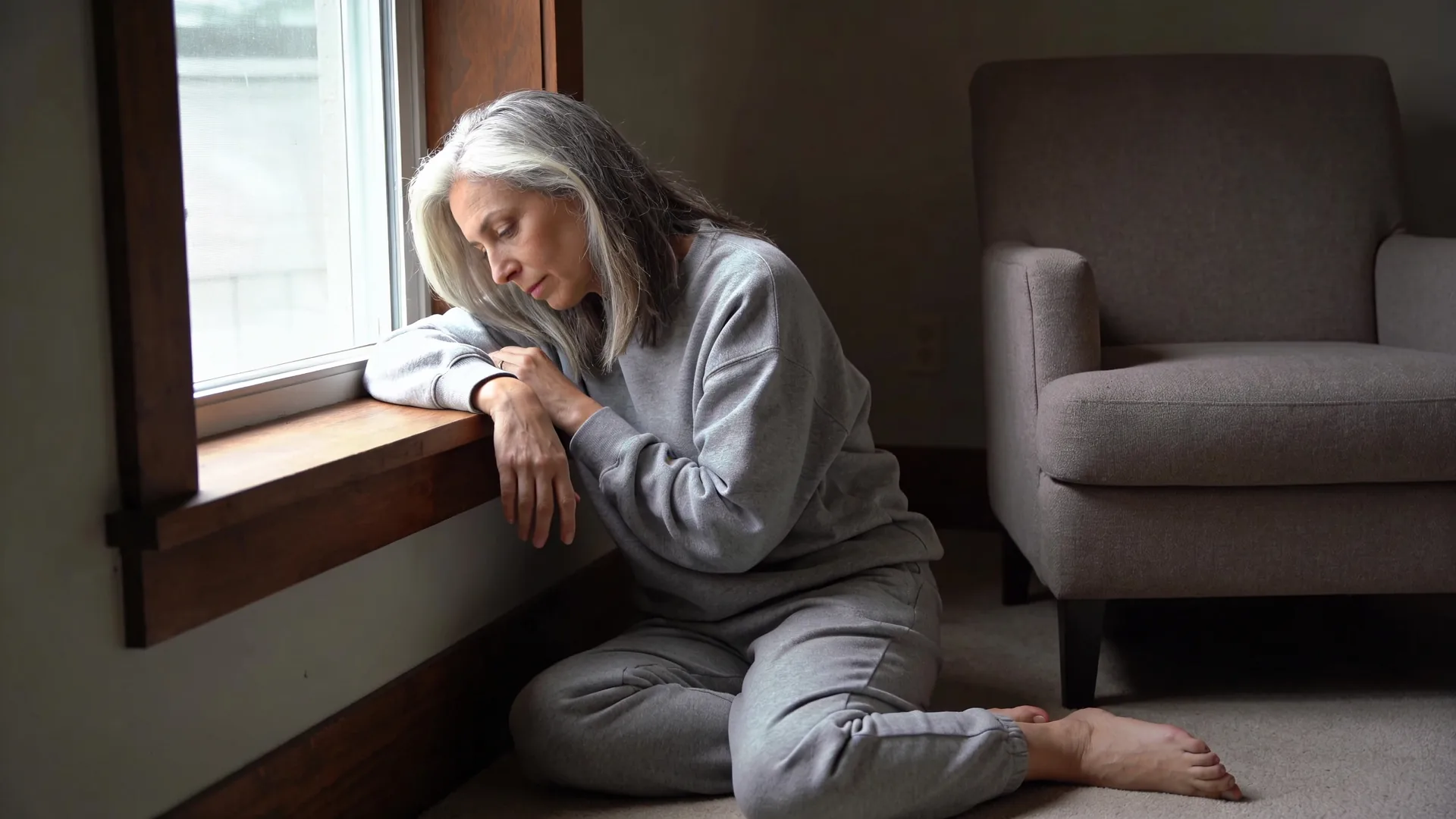 Relaxed forearms resting on a wooden windowsill showing body softening after somatic grounding practice