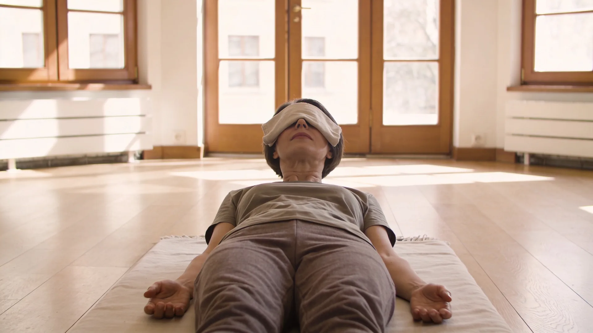Man lying on floor in body practice position during 12-minute spiritual awakening wave exercise