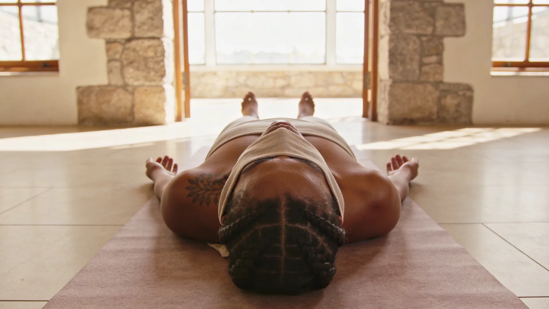 Woman stepping through stone doorway into daylight representing what tattoos for emotional healing can and cannot carry