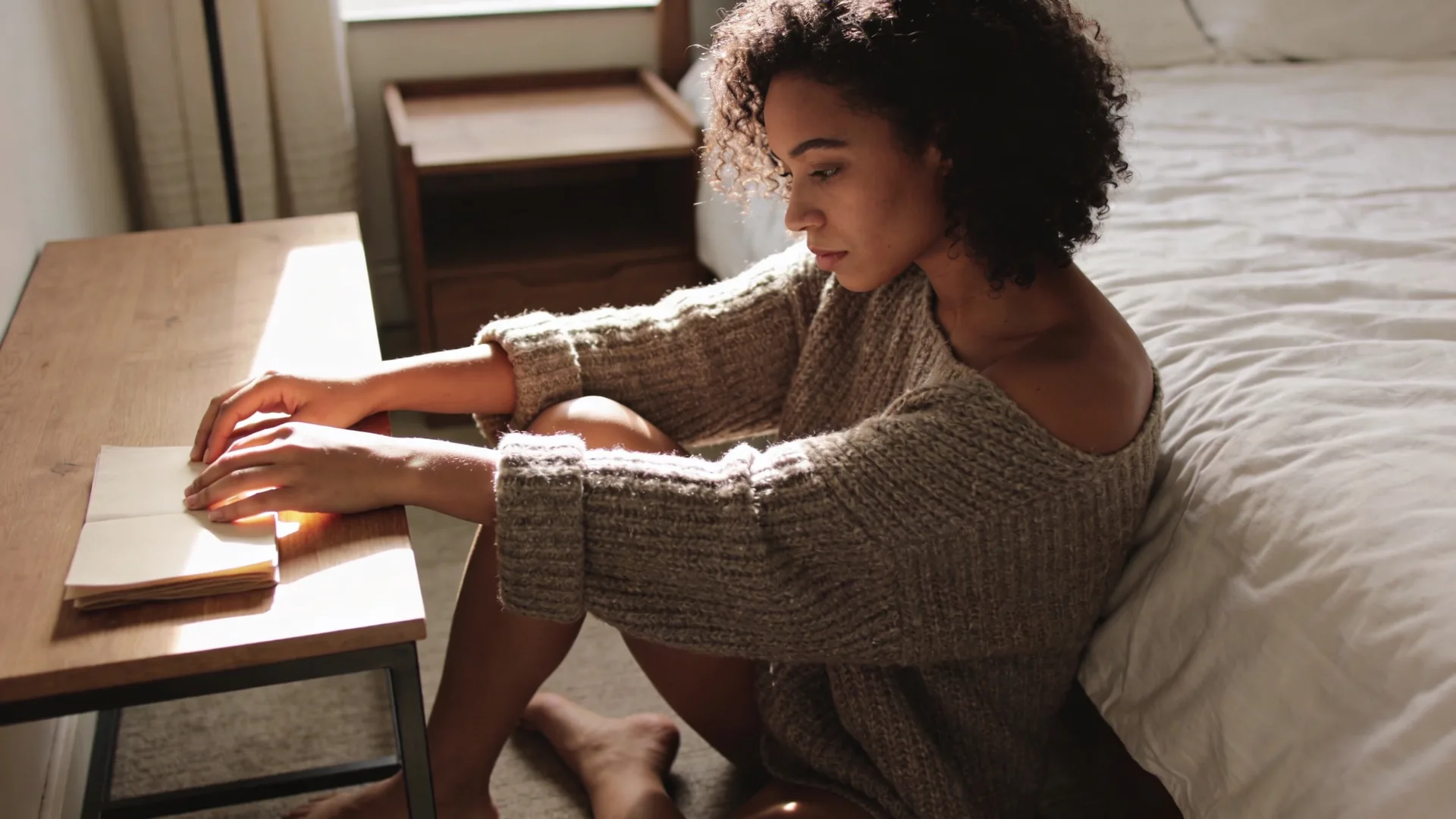 Hands resting on a wooden table beside a ceramic mug and folded paper, symbolizing your next step in leaving a toxic relationship