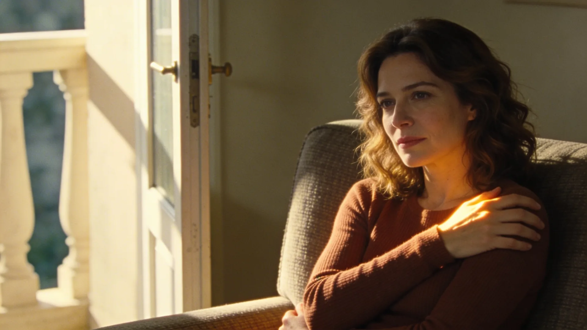 Woman standing at open balcony doorway in soft light, what shifts once you stop measuring your grief