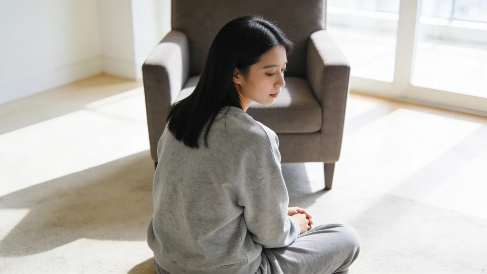 Bare feet and palm-down hand on woven mat in evening light for a 12-minute feeling practice