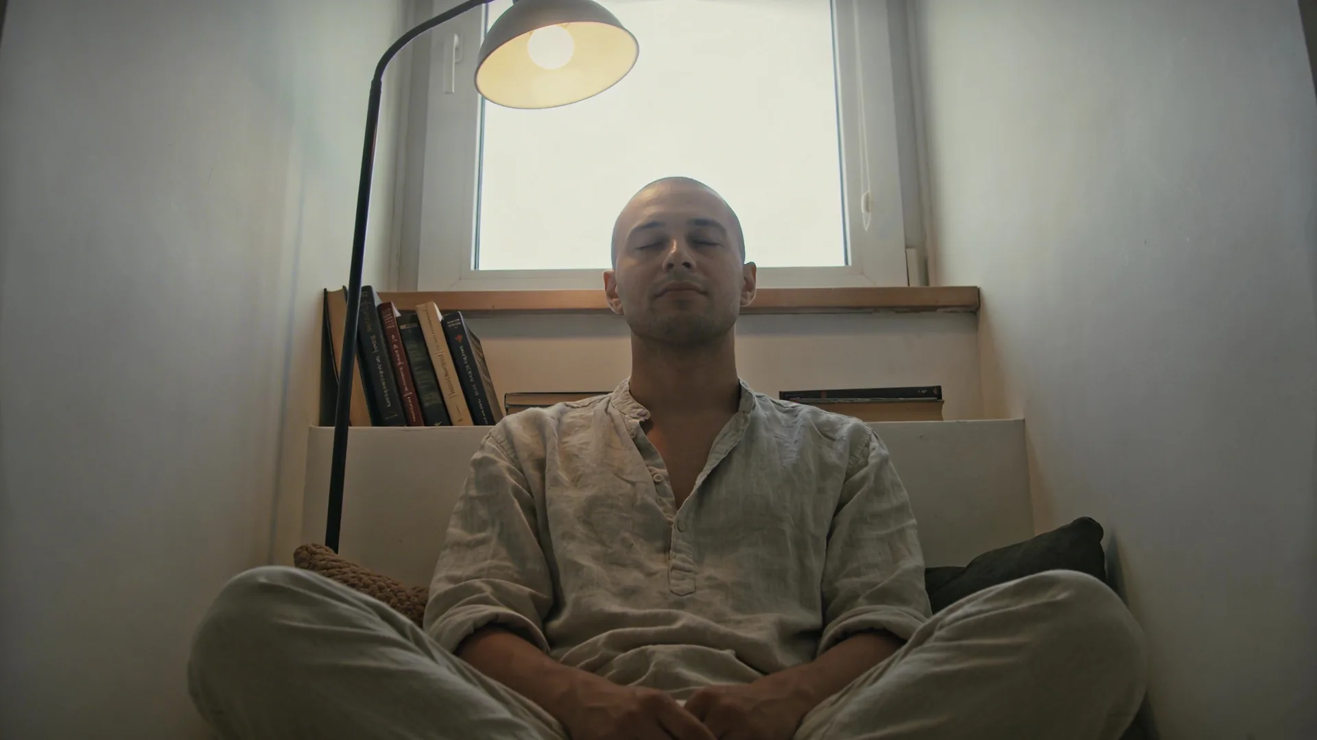 Man touching his throat during quiet who am i really spiritual inquiry moment in sunlit kitchen