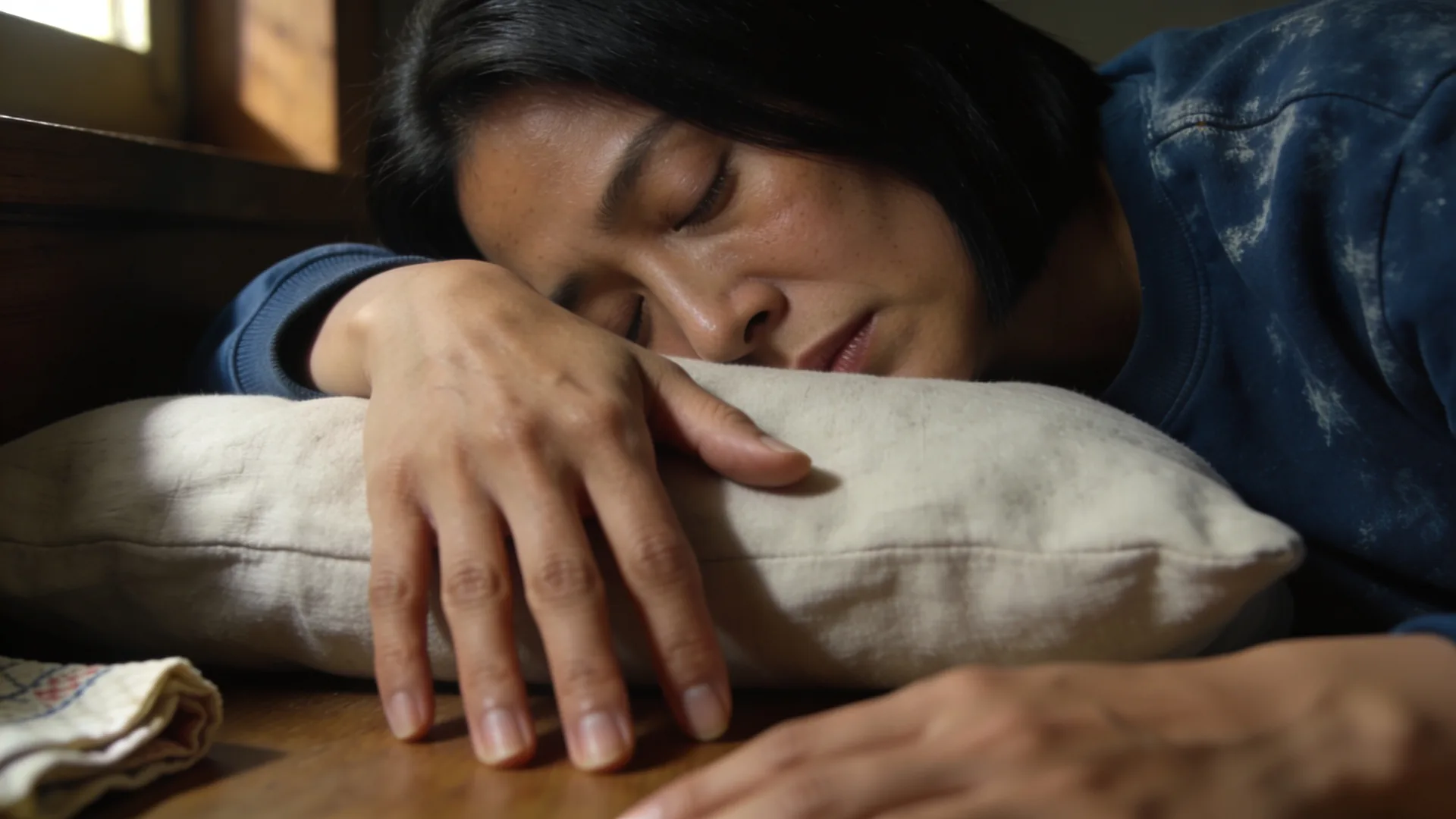 Why cant i cry anymore — close-up of an open relaxed hand on a linen pillow in soft daylight